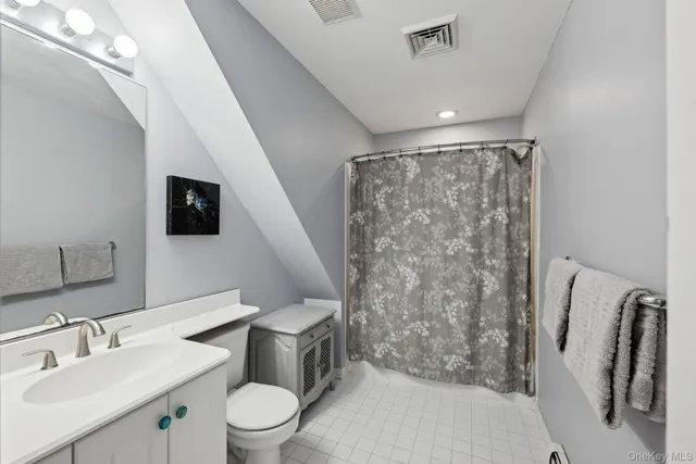 a bathroom with a toilet sink and a mirror