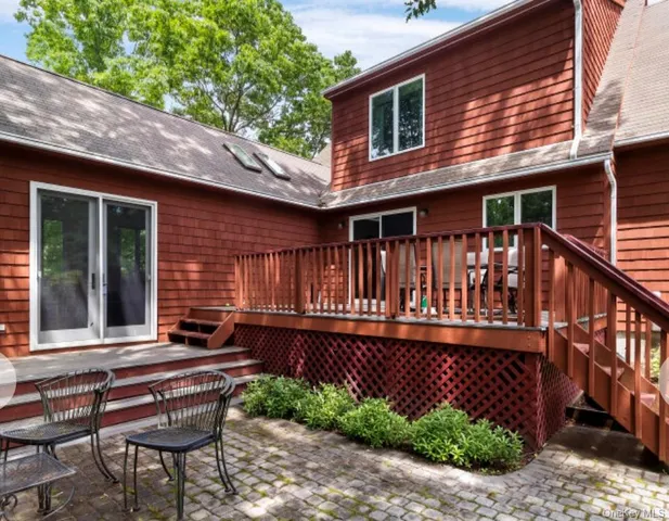 a view of a house with wooden deck and furniture