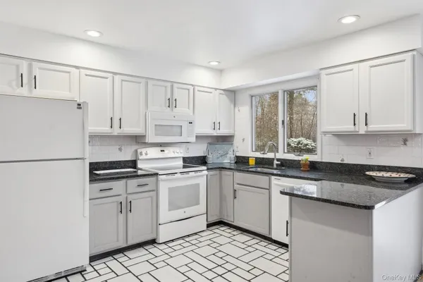 a kitchen with white cabinets sink and white appliances