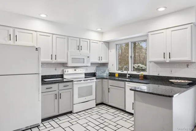 a kitchen with white cabinets sink and white appliances