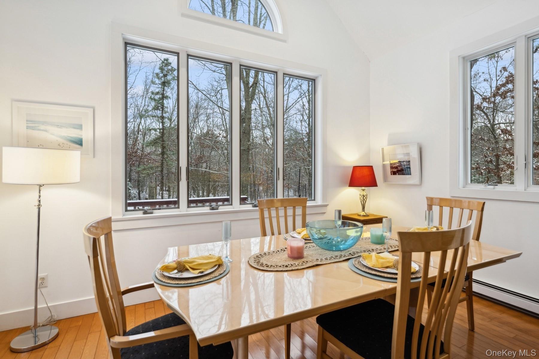 12 Hildreth Road Hampton Bays, NY 11946 - Photo 10 of 21 a view of a dining room with furniture a chandelier and wooden floor