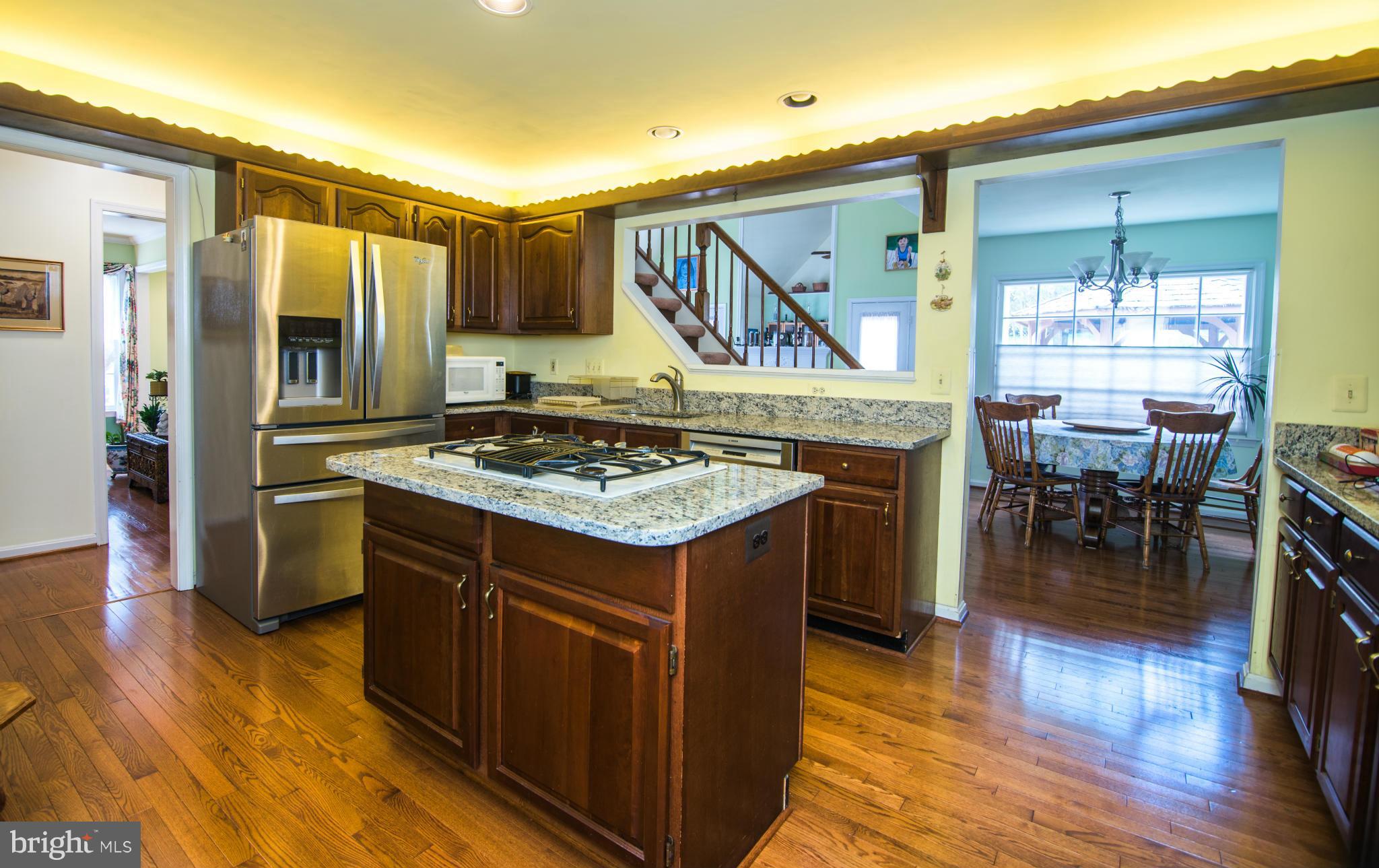 4 Midsummer Court Gaithersburg, MD 20878 - Photo 2 of 24 a kitchen with a stove a refrigerator and a dining table