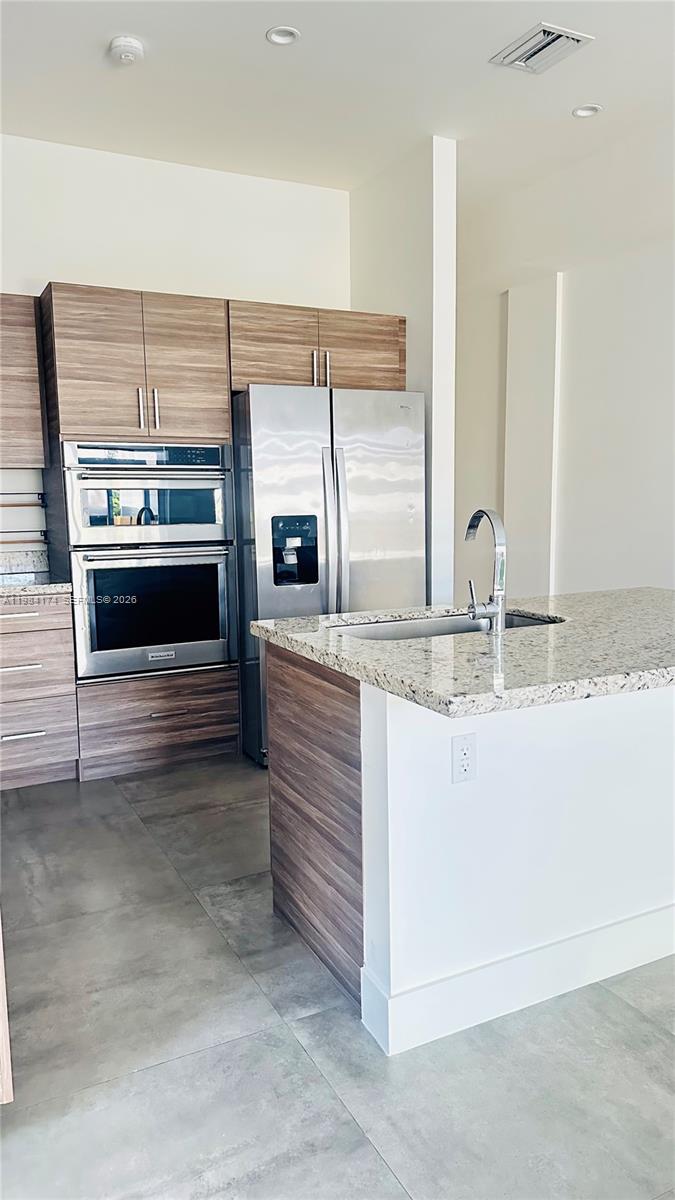3653 Southwest 25th Street, Unit 3653 Miami, FL 33133 - Photo 15 of 18 a kitchen with stainless steel appliances granite countertop a stove and a sink