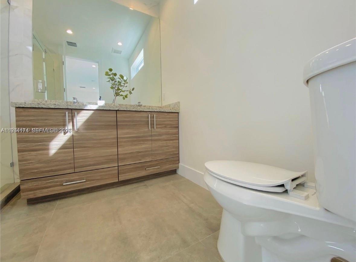 3653 Southwest 25th Street, Unit 3653 Miami, FL 33133 - Photo 5 of 18 a bathroom with a toilet a sink and mirror