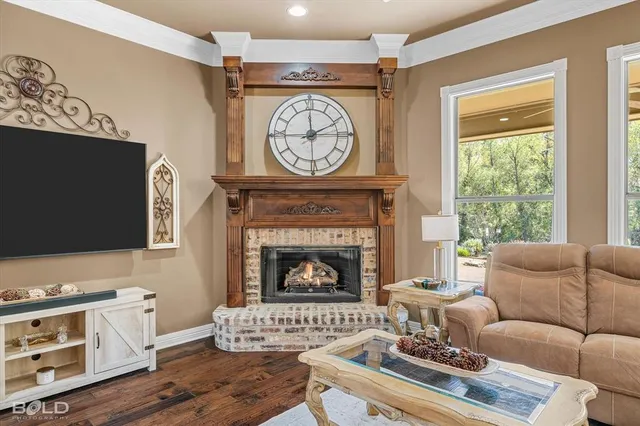 a living room with furniture a clock and a flat screen tv