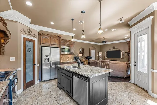 a kitchen with a counter top space a sink appliances and cabinets