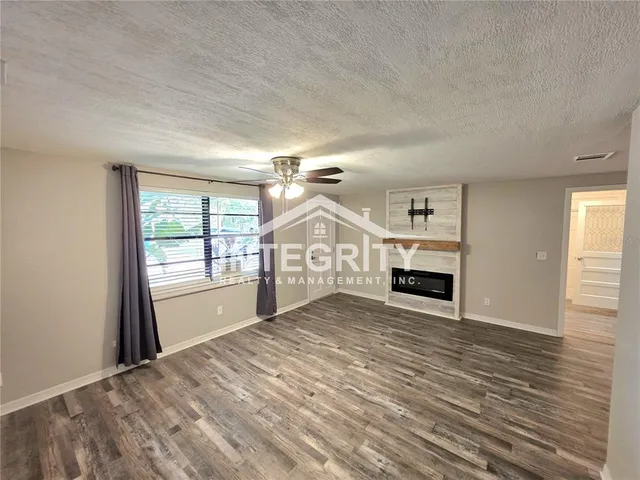 an empty room with windows and fireplace