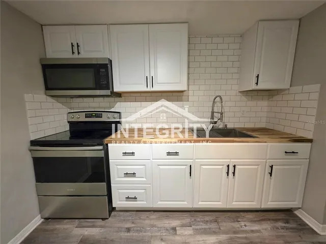 a view of a livingroom with wooden floor and a ceiling fan