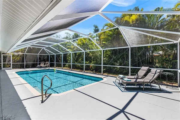 a view of a swimming pool with a patio and a yard