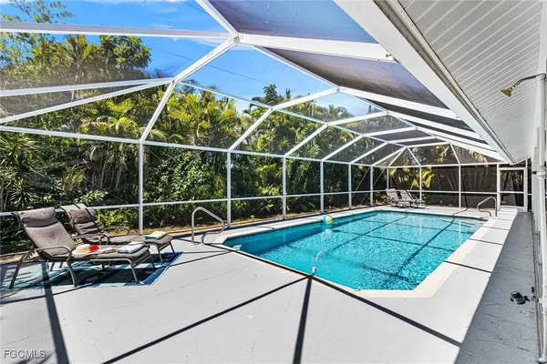 a view of a swimming pool with outdoor seating and plants