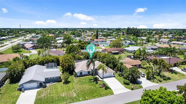 an aerial view of residential houses with outdoor space and trees