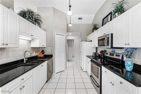 a kitchen with a sink a stove and cabinets