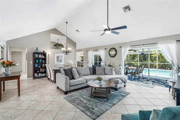 a living room with furniture a large window and chandelier