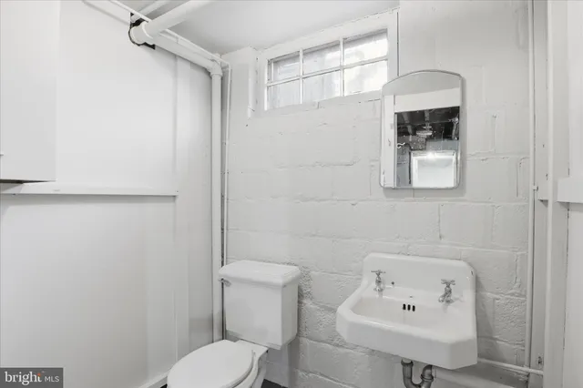 a bathroom with a sink a toilet and mirror