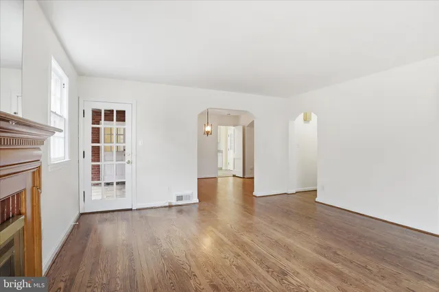 a view of empty room with wooden floor and fireplace