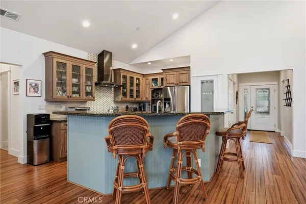 a living room with furniture kitchen view and a wooden floor