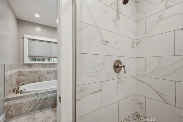 a view of a hallway with wooden floor and a bathroom