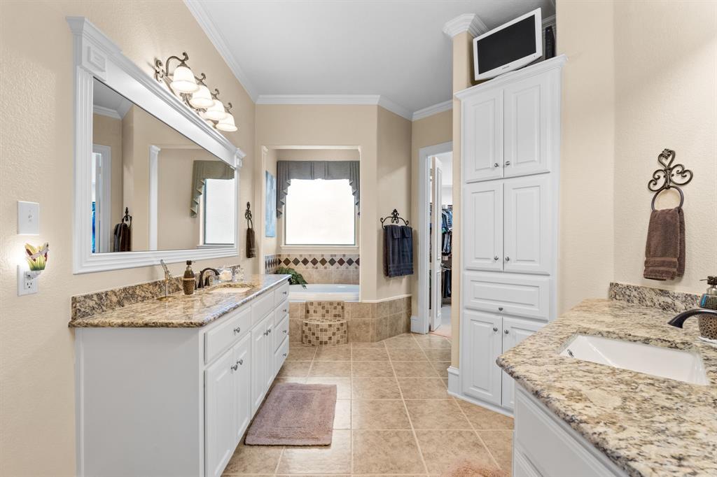 10072 Bluffview Circle Pilot Point, TX 76258 - Photo 14 of 38 Bathroom with two vanities, crown molding, a garden tub, and light tile patterned flooring