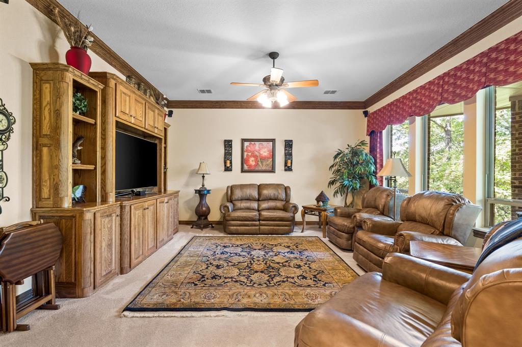 10072 Bluffview Circle Pilot Point, TX 76258 - Photo 22 of 38 Living room with crown molding, light carpet, and ceiling fan