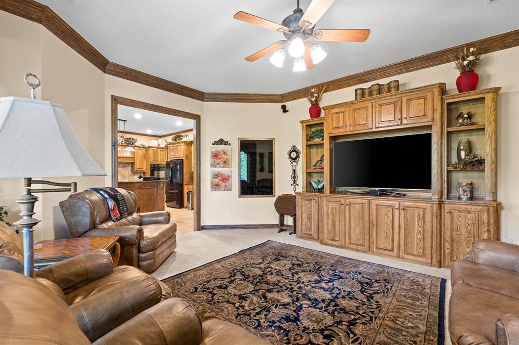 10072 Bluffview Circle Pilot Point, TX 76258 - Photo 23 of 38 Living room with ornamental molding, a ceiling fan, and light carpet