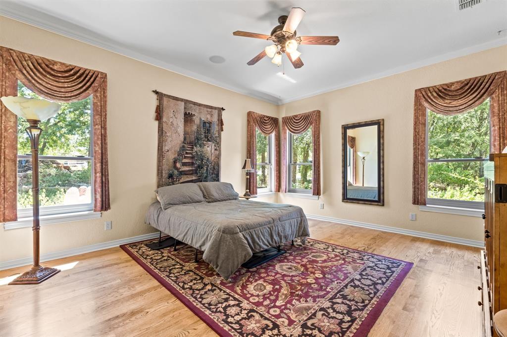 10072 Bluffview Circle Pilot Point, TX 76258 - Photo 24 of 38 Bedroom with light wood-style flooring, multiple windows, ornamental molding, and ceiling fan