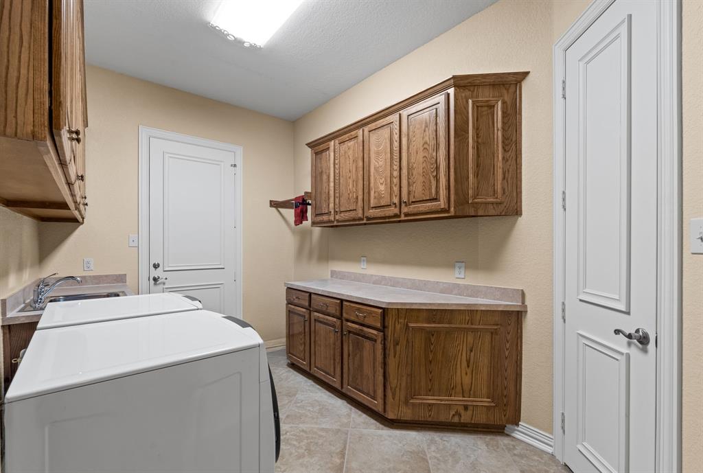 10072 Bluffview Circle Pilot Point, TX 76258 - Photo 29 of 38 Laundry room with washer / dryer, cabinet space, and light tile patterned flooring