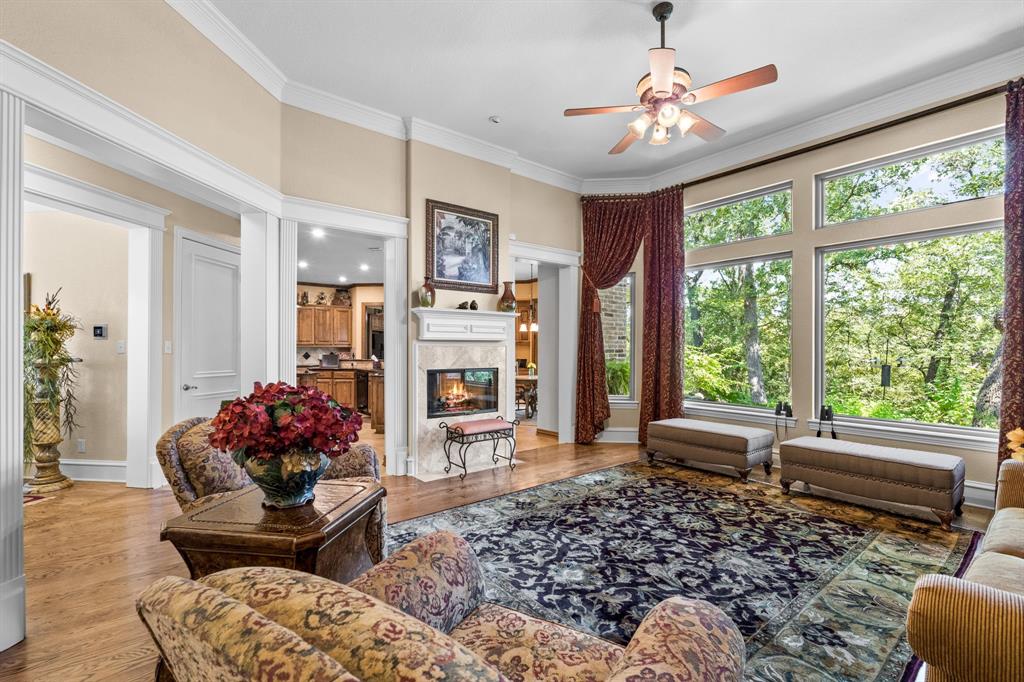 10072 Bluffview Circle Pilot Point, TX 76258 - Photo 3 of 38 Living area with light wood finished floors, crown molding, ceiling fan, and a high end fireplace