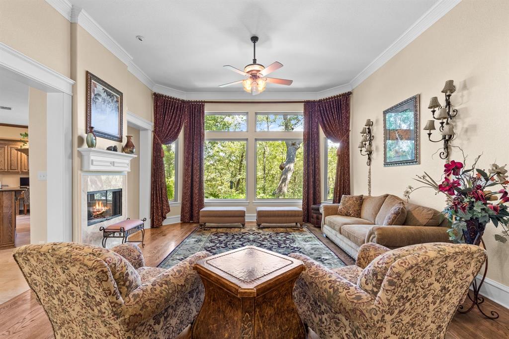 10072 Bluffview Circle Pilot Point, TX 76258 - Photo 5 of 38 Living area featuring ceiling fan, a tile fireplace, wood finished floors, and crown molding