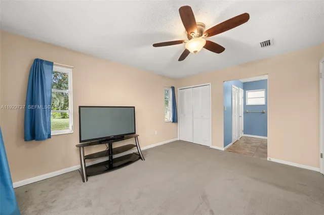a living room with furniture and a ceiling fan