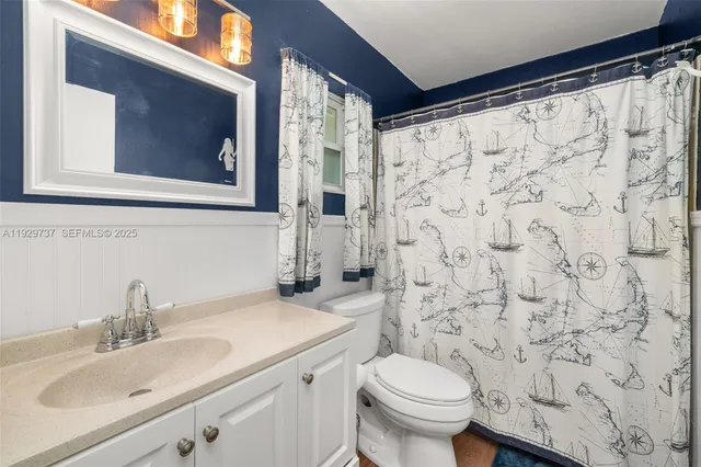 a bathroom with a sink a toilet and shower curtain