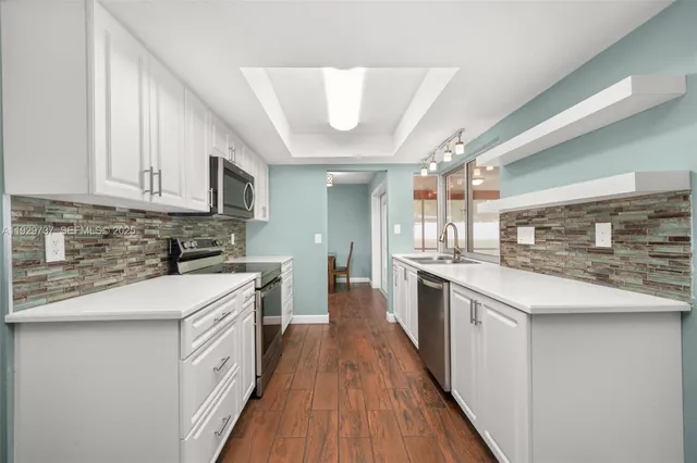 a kitchen with stainless steel appliances granite countertop wooden cabinets a stove top oven a sink and dishwasher