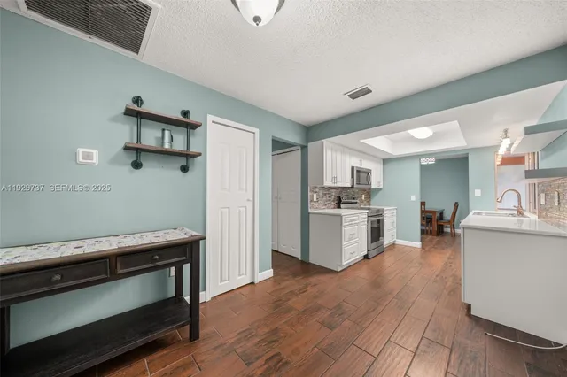 a kitchen with cabinets and wooden floor