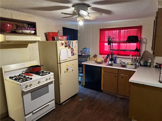 a kitchen with refrigerator a stove a microwave and red cabinets
