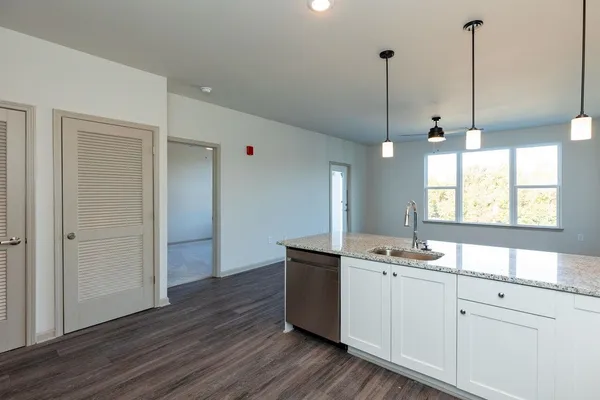 a kitchen with a sink window and wooden floor