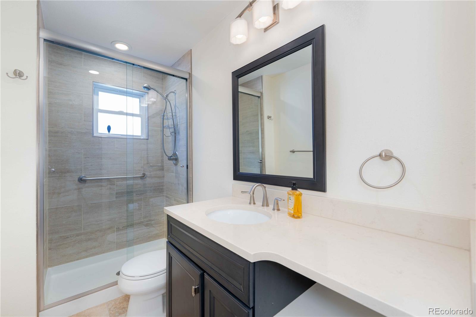 3815 East Easter Place Centennial, CO 80122 - Photo 21 of 35 a bathroom with a sink a toilet a shower and a mirror