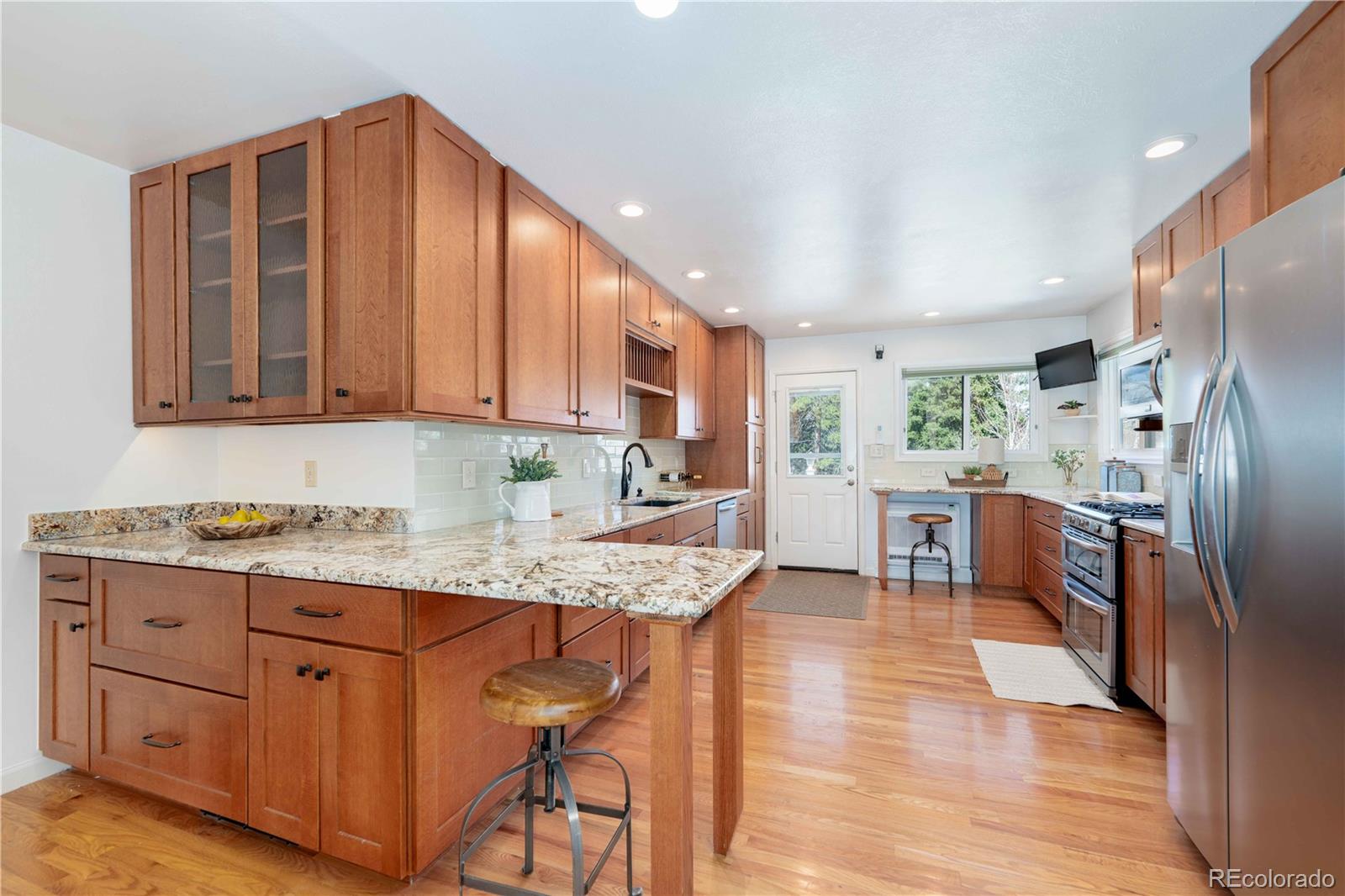 3815 East Easter Place Centennial, CO 80122 - Photo 5 of 35 a kitchen with stainless steel appliances granite countertop a refrigerator sink and wooden cabinets