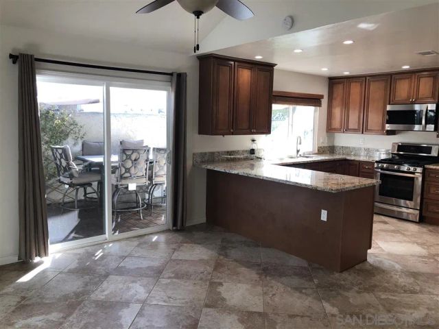 a kitchen with stainless steel appliances granite countertop a sink a stove and a refrigerator