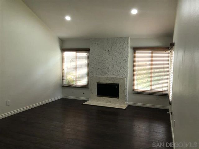 a living room with hard wood floors and a fireplace