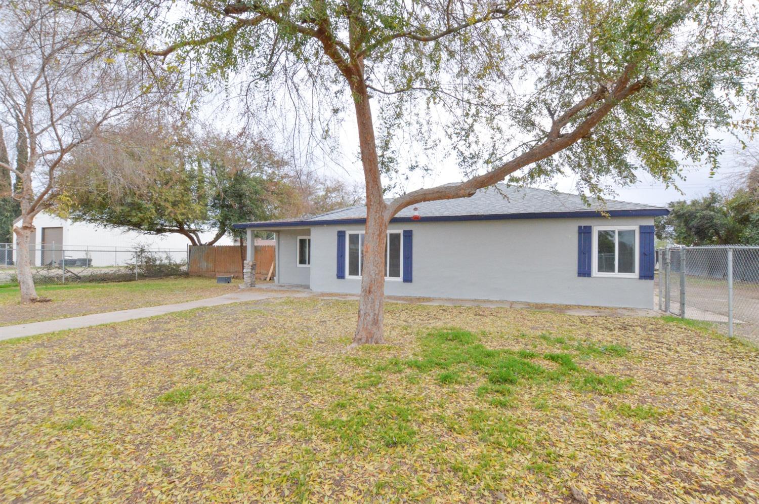4613 West Andrews Fresno, CA 93722 - Photo 1 of 20 a house with trees in front of it