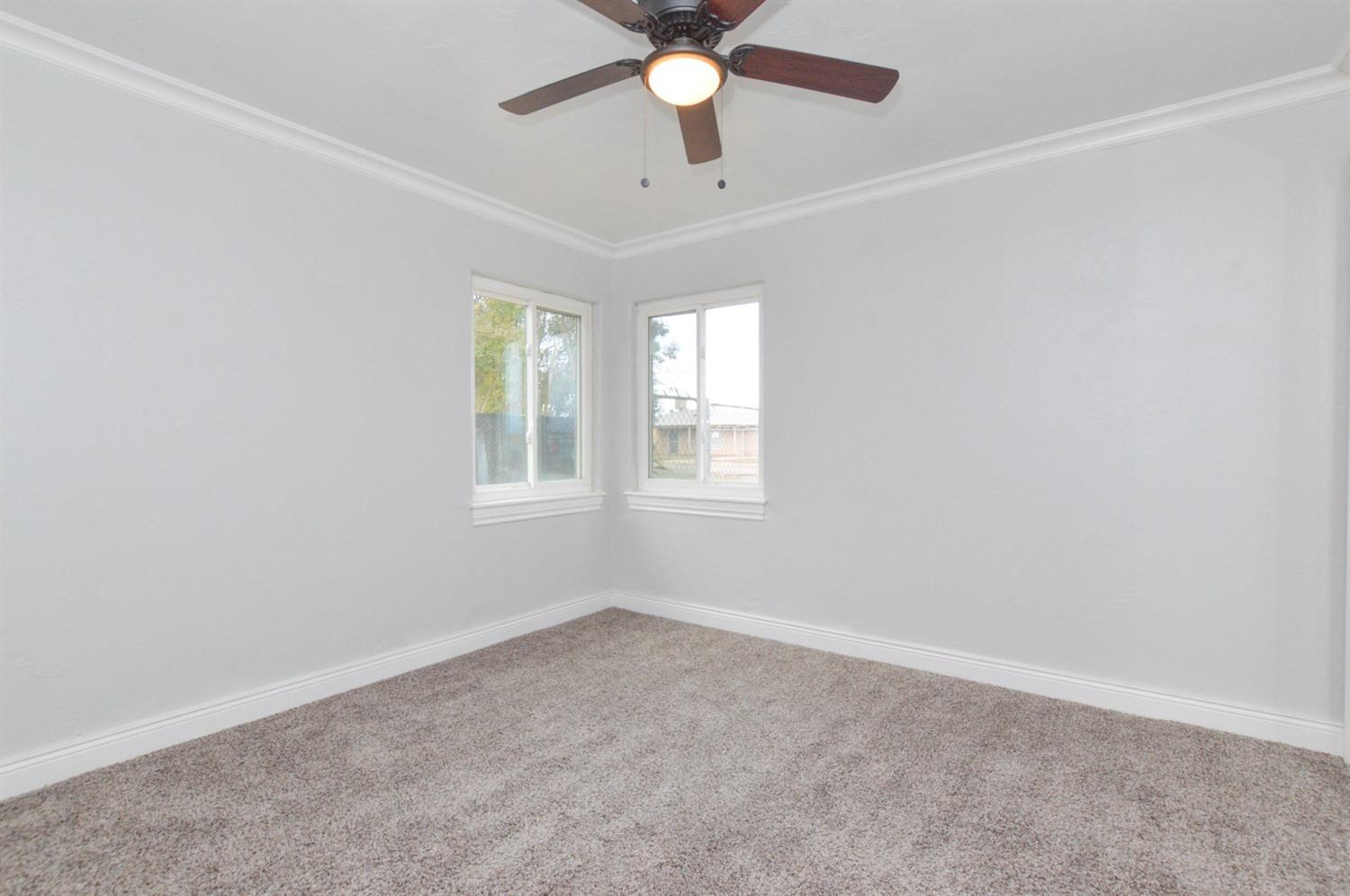 4613 West Andrews Fresno, CA 93722 - Photo 12 of 20 an empty room with windows and ceiling fan