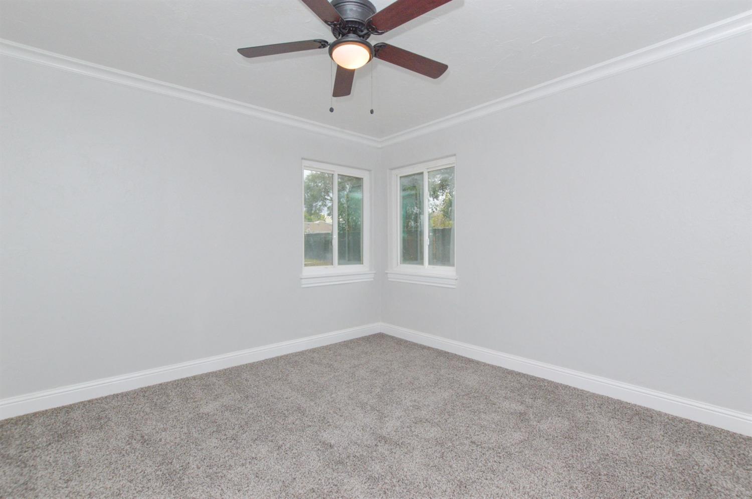 4613 West Andrews Fresno, CA 93722 - Photo 15 of 20 an empty room with a window and a fan