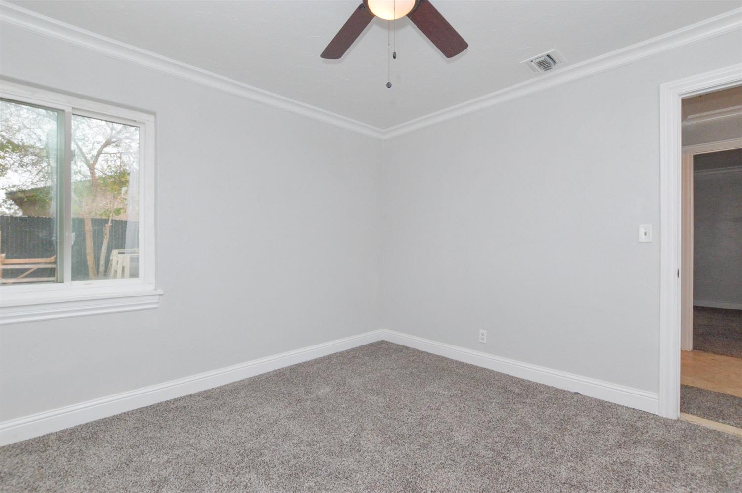 4613 West Andrews Fresno, CA 93722 - Photo 16 of 20 an empty room with a window and a fan