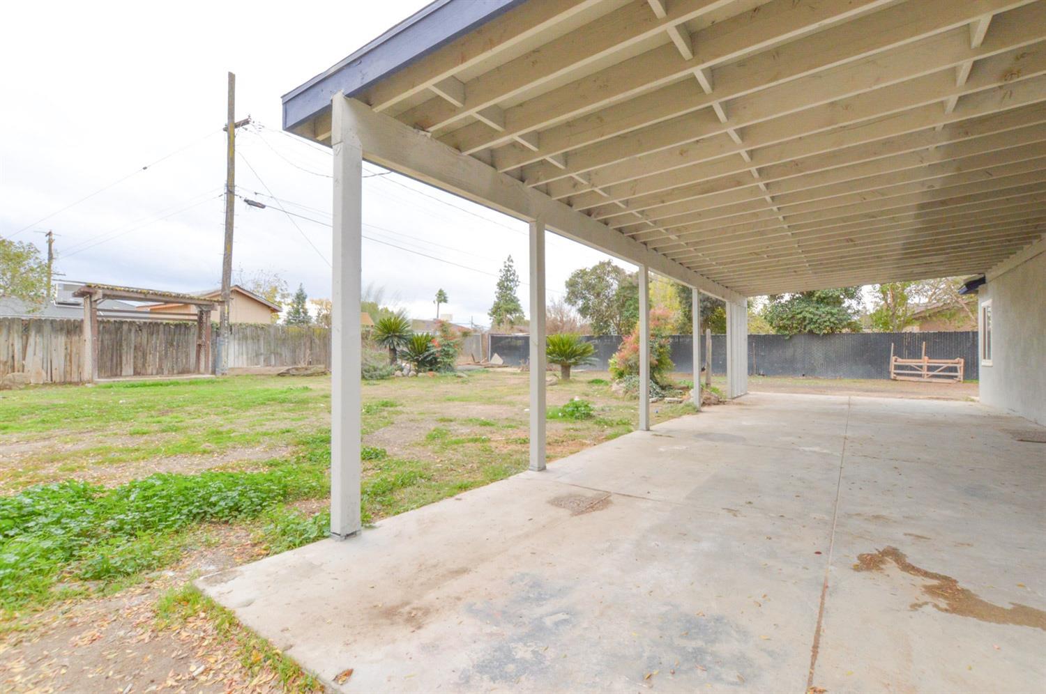 4613 West Andrews Fresno, CA 93722 - Photo 17 of 20 a view of a house with a big yard and porch
