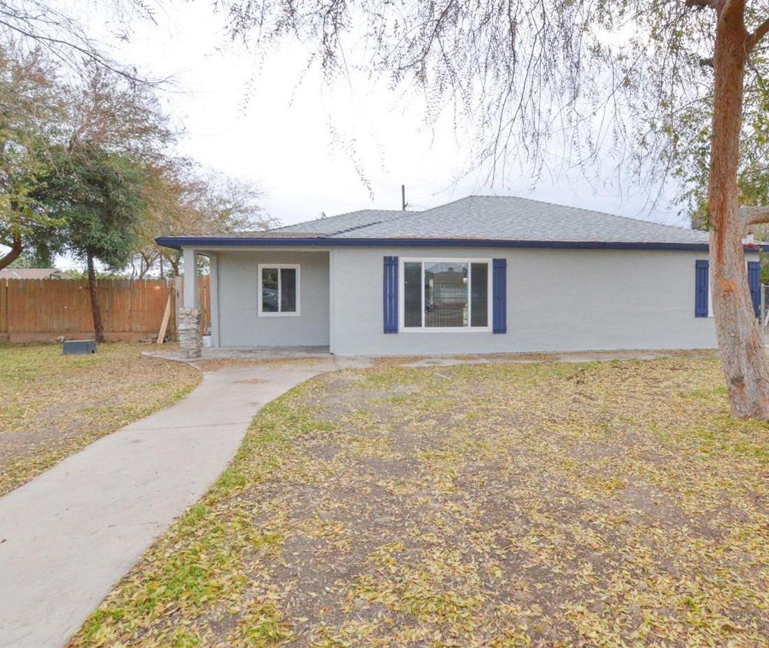 4613 West Andrews Fresno, CA 93722 - Photo 2 of 20 a house that has a tree in front of it