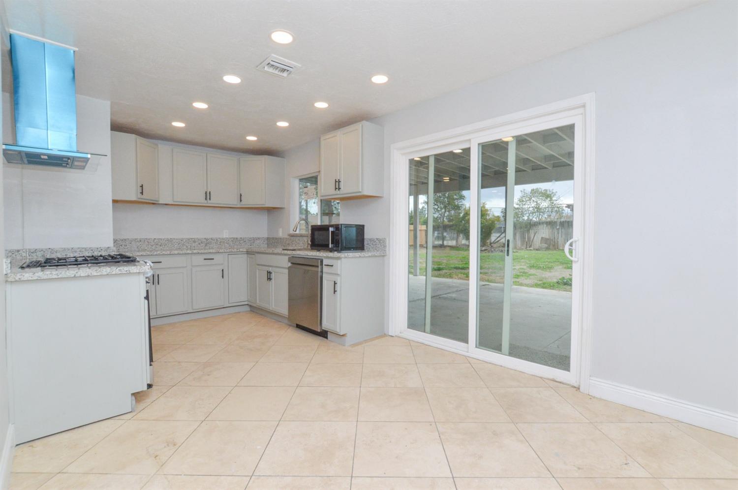 4613 West Andrews Fresno, CA 93722 - Photo 7 of 20 a kitchen with a sink a counter top space cabinets and stainless steel appliances
