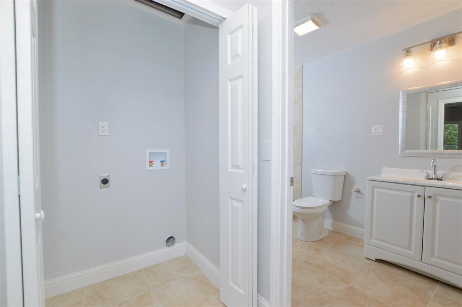 4613 West Andrews Fresno, CA 93722 - Photo 10 of 20 a bathroom with a granite countertop toilet and sink