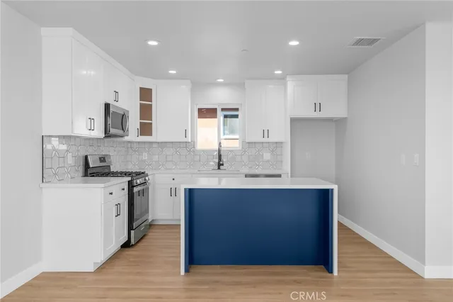 a kitchen with stainless steel appliances granite countertop a sink stove and wooden floor