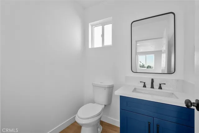 a bathroom with a toilet sink vanity and mirror