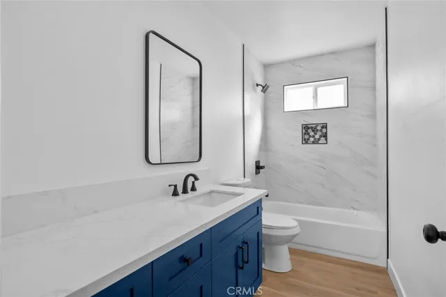 a bathroom with a double vanity sink toilet a shower and a mirror