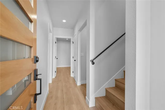 a view of a hallway with wooden floor and staircase